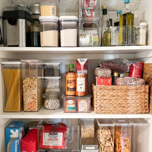 A small pantry is stoked with an assortment of grains, pasta, and canned goods.