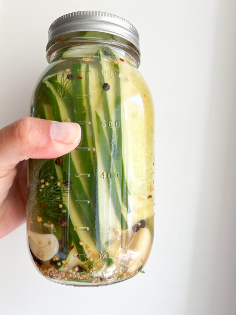 A Ball jar holds Refrigerator Pickles made from pickled cucumbers.