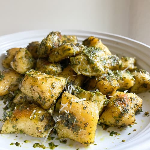 A large plate of gnocchi is made with acorn squash and tossed with basil pesto for an autumnal version of this classic Italian dish.