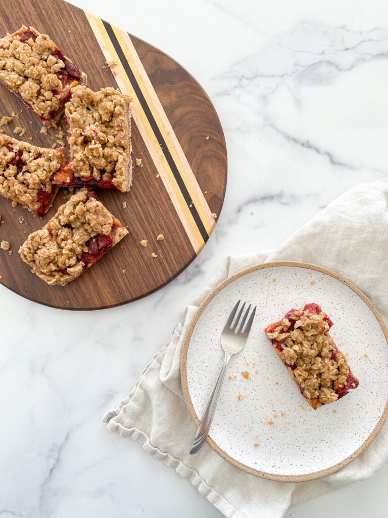 A platter of stone fruit crumble bars are displayed in flatlay form.