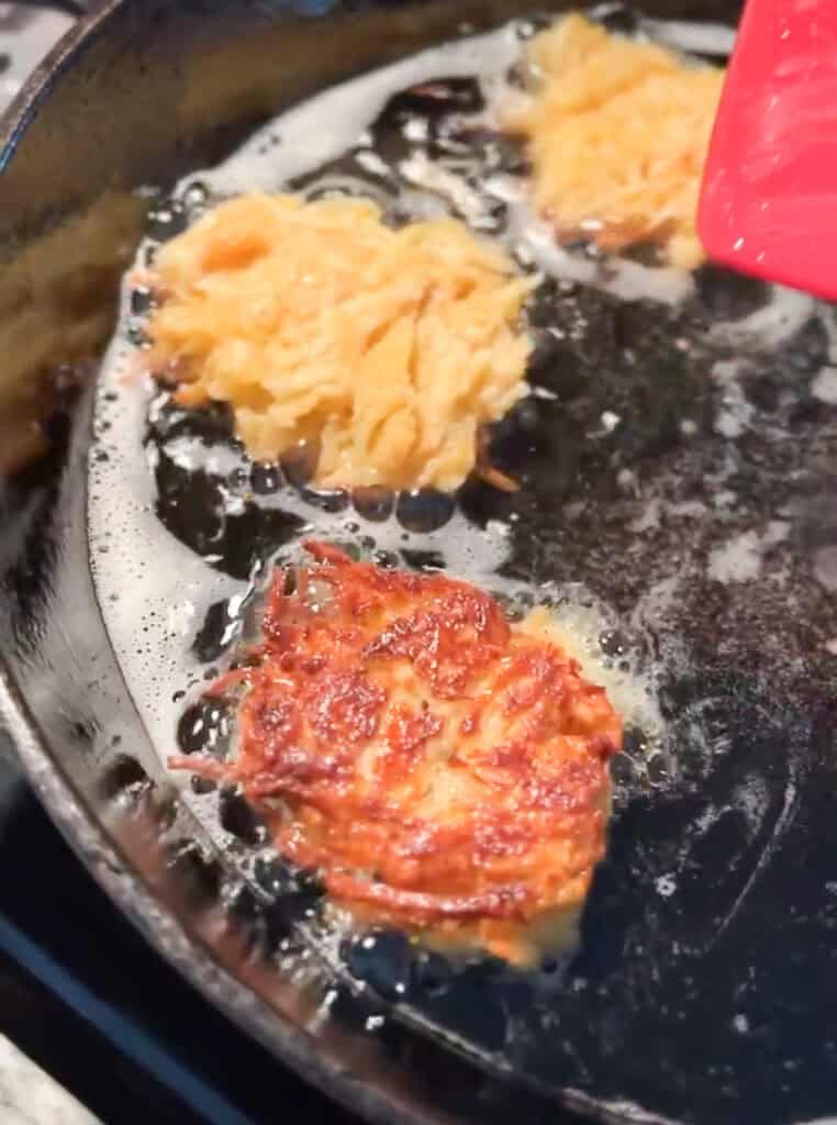 Photo of Gluten Free Spaghetti Squash and Red Potato Latkes during the first half of frying.