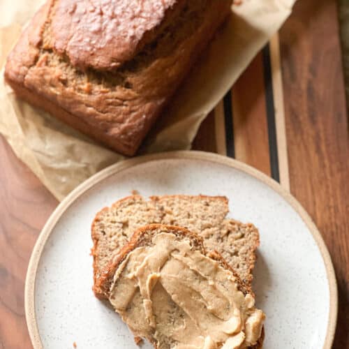A speckled plate holds a couple slices of banana bread. They're slathered in a maple cinnamon butter.