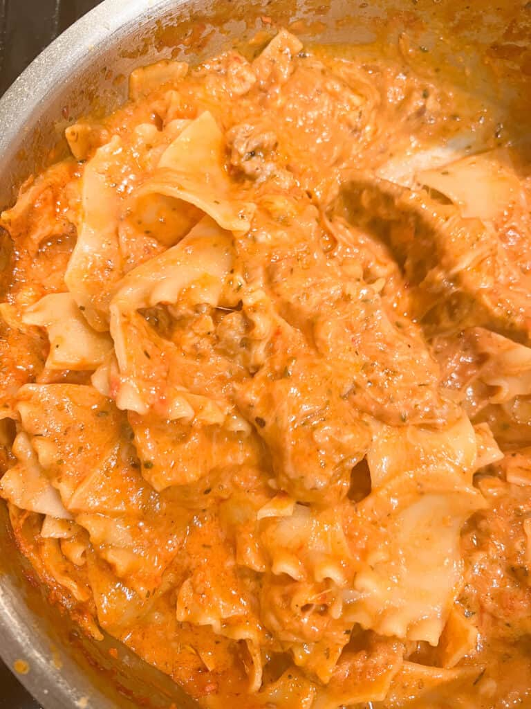 A pot of pasta that is lasagna soup. The lasagna noodles are broken up and coated in creamy tomato sauce and cheese.