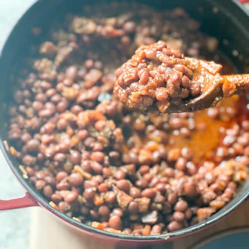 A large dutch oven holds a big batch of stewed Santa maria-Style Pinquito Beans.