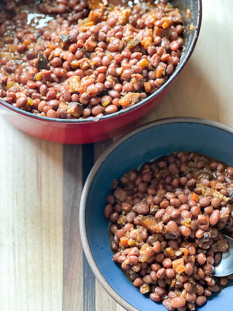 A blue bowl holds a portioned serving of the slow Stewed Santa Maria-Style Pinquito Beans. 