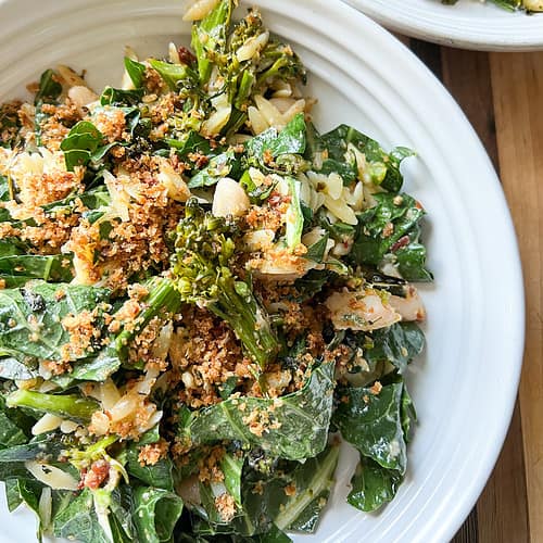 A large white bowl holds broccolini and beans pasta salad made with broccolini, broccoli greens, white beans and crispy breadcrumbs tossed in a lemon parmesan vinaigrette.