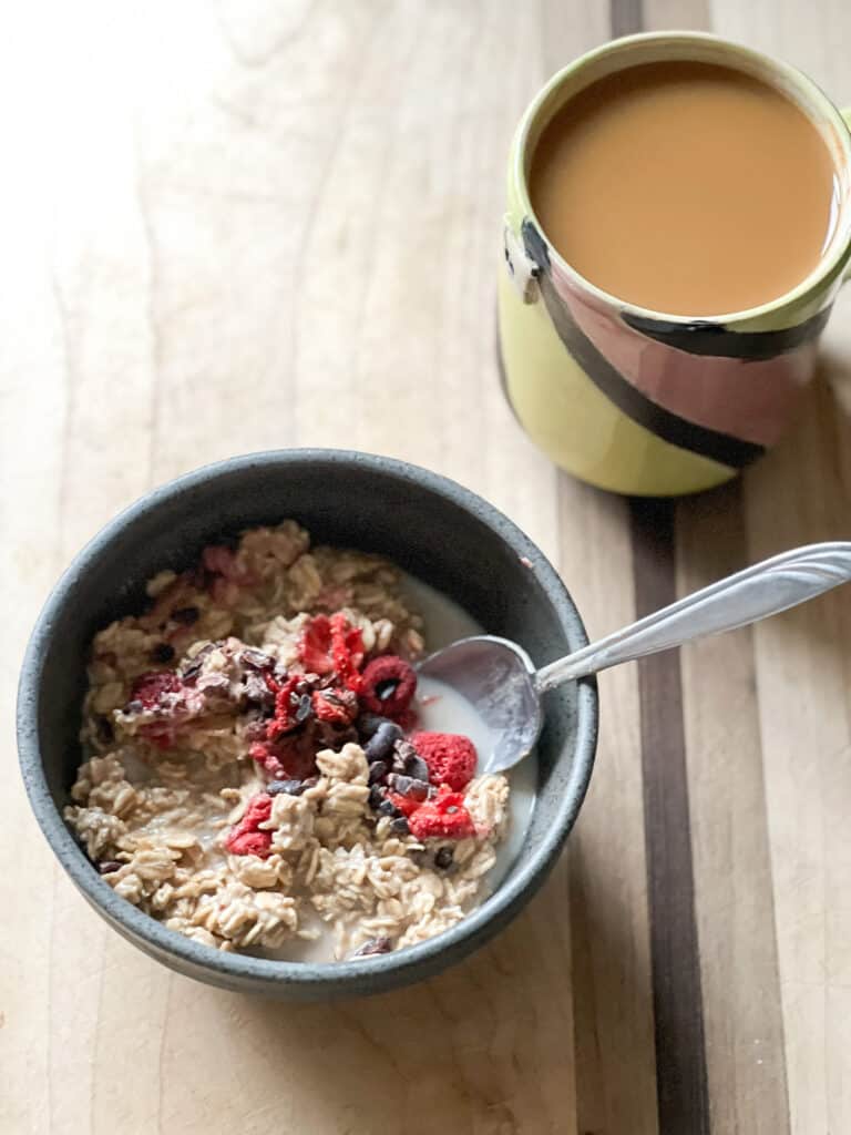 A small bowl holds a batch of overnight oats with chocolate and berries.