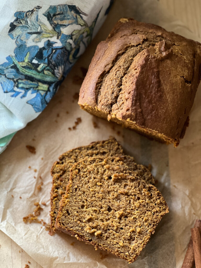 Slices of freshly baked pumpkin bread are stacked gently on top of one another. 