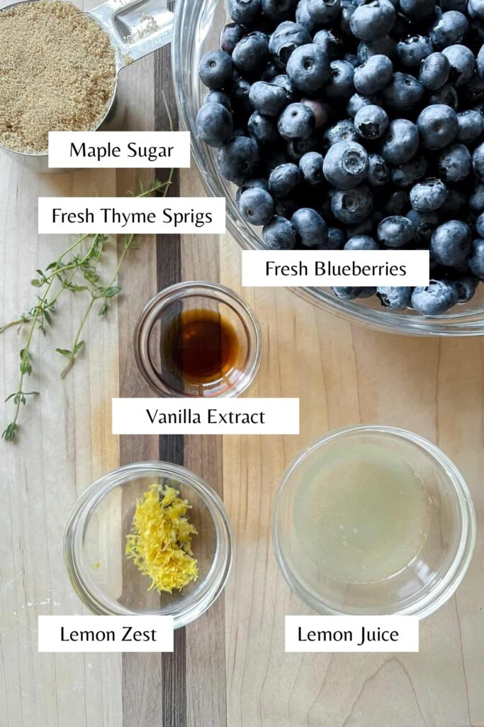 Ingredients to make blueberry butter on a counter with labels to identify each one.