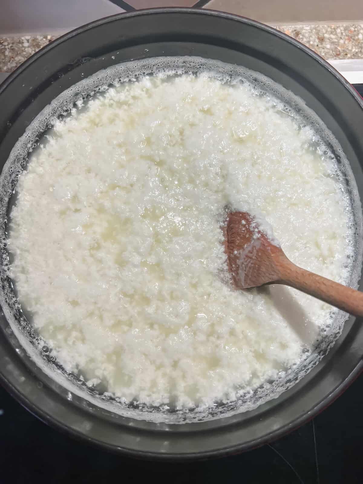 The cottage cheese in a pot after lemon juice is added and it's starting to curdle.