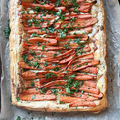 A flatlay image of the Roast Carrot Tart in Puff Pastry with golden brown edges and caramelized roasted carrots.