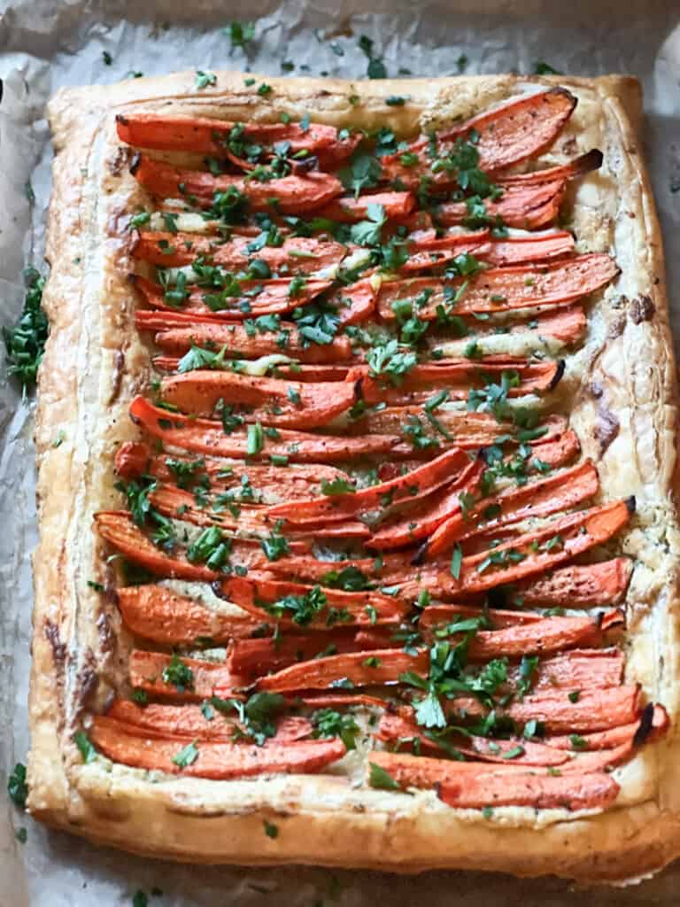 A flatlay image of the Roast Carrot Tart in Puff Pastry with golden brown edges and caramelized roasted carrots.