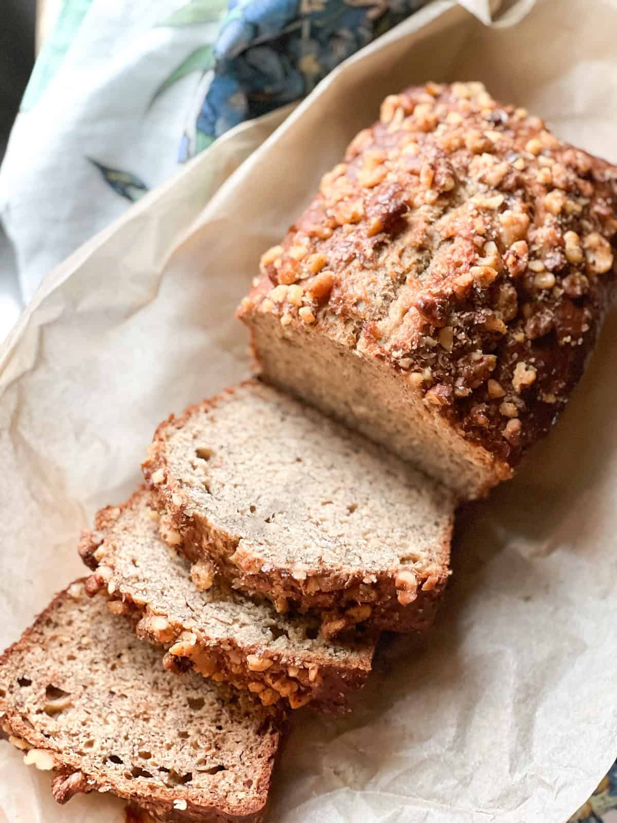 Baked walnut banana bread with three slices leaning over.