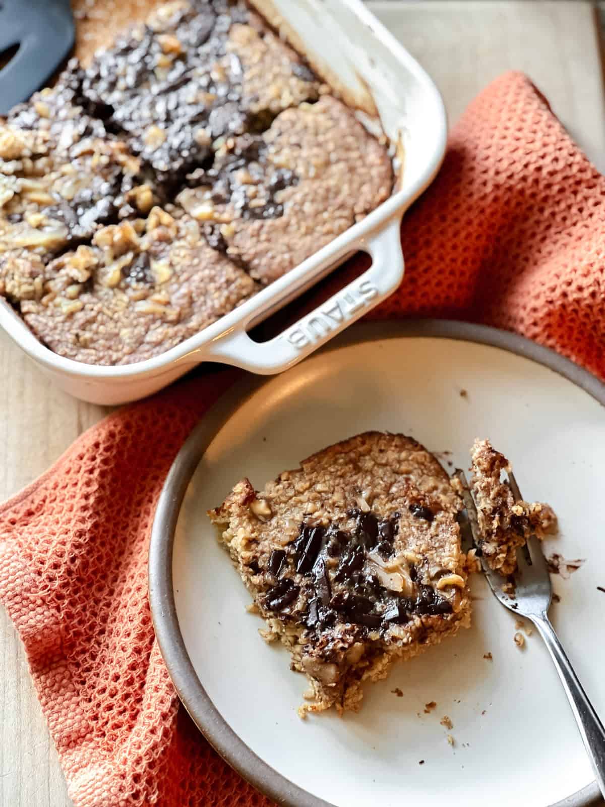Baked banana bread oats served on a plate and more in a casserole dish in the background.