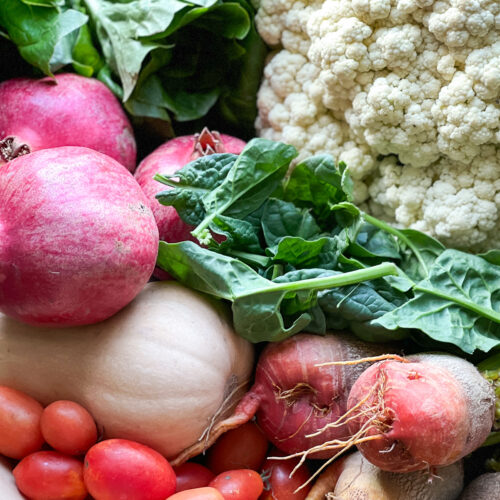 Portrait shot of fresh produce for Thanksgiving Week in Dinner Plans Week 48. Featuring carrots, beets, cauliflower, butternut squash, and seasonal greens.