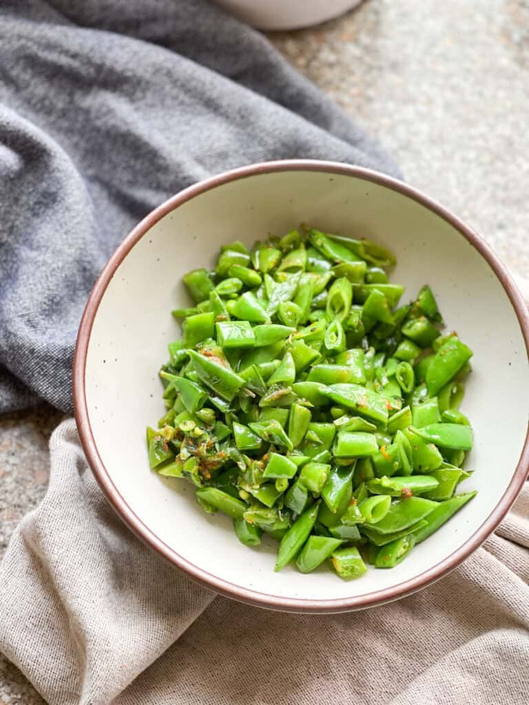 Portrait photo of sautéed sugar snap peas with fresh citrus zest and mint.