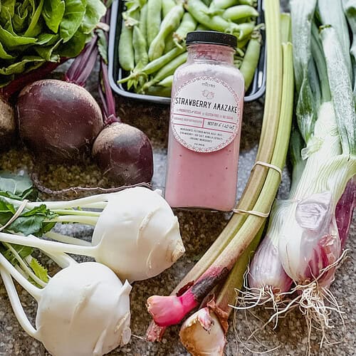 Flatlay photo of early summer produce for Dinner Plans Week 25 featuring red beets, kohlrabi, rhubarb, sugar snap peas, and torpedo onions.