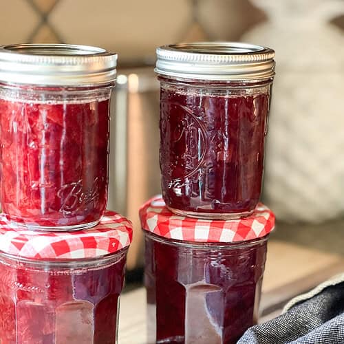 Portrait photo of four finished jars of the Santa Rosa Plum Compote Recipe.