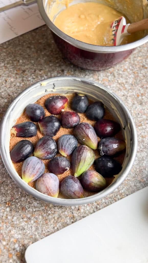 Overhead image of the fig cake recipe with fresh figs lining the bottom of the cake pan. 