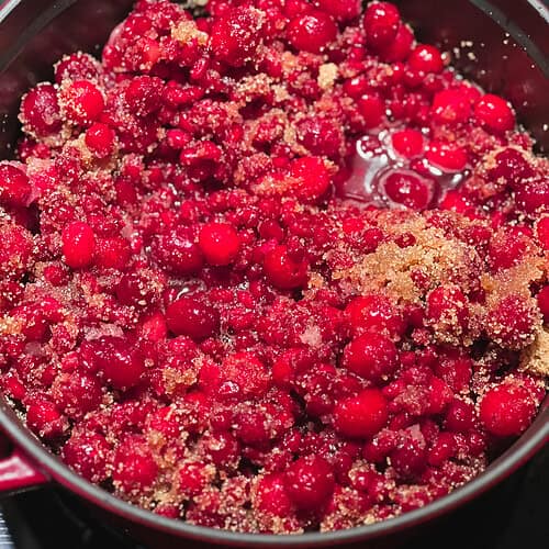 Picture of nearly finished Pomegranate Cranberry Sauce with Bourbon Recipe in a large dutch oven.