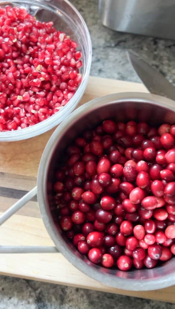 Portrait of fresh cranberries and pomegranates for the Pomegranate Cranberry Sauce with Bourbon Recipe.
