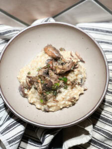 Finished photo of Mushroom Risotto with Easy Wine Pairing Recipe topped with savory sauteed mushrooms.