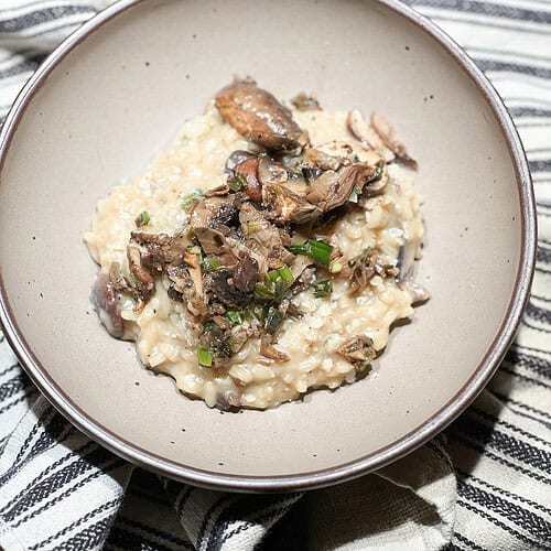 Finished photo of Mushroom Risotto with Easy Wine Pairing Recipe topped with savory sauteed mushrooms.