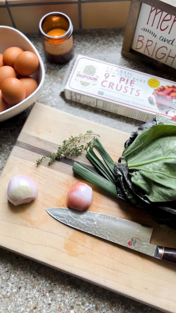 Layout of ingredients for the Seasonal Christmas Quiche Recipe featuring shallots, pak choi, herbs, pie crust, and eggs. 