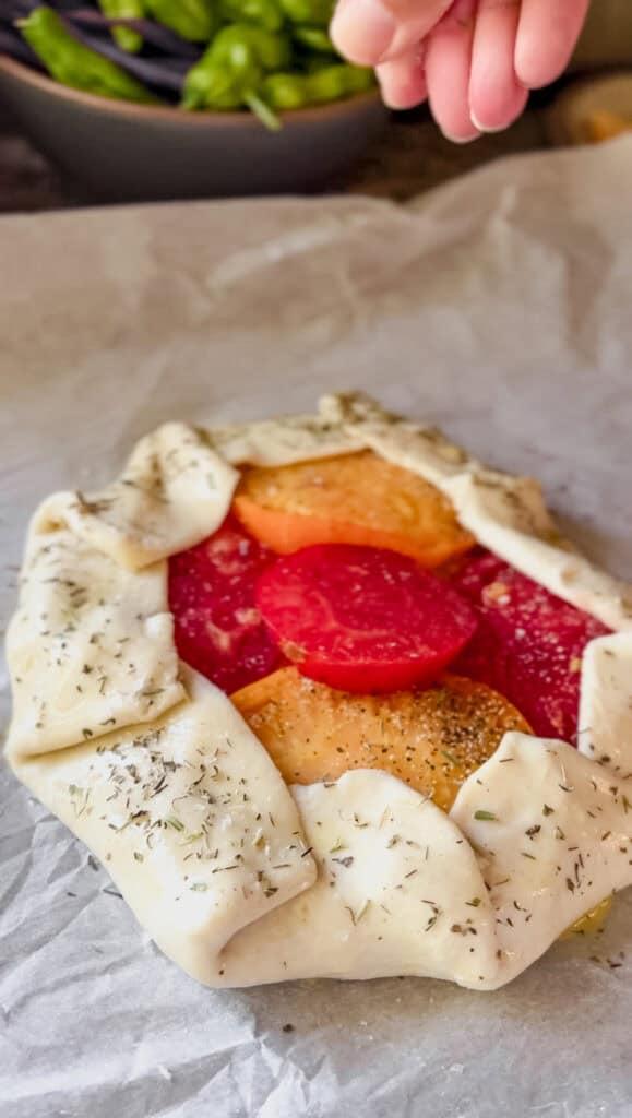 The Heirloom Tomato galette is sprinkled with flaky salt and dried herbs de provence prior to baking. 