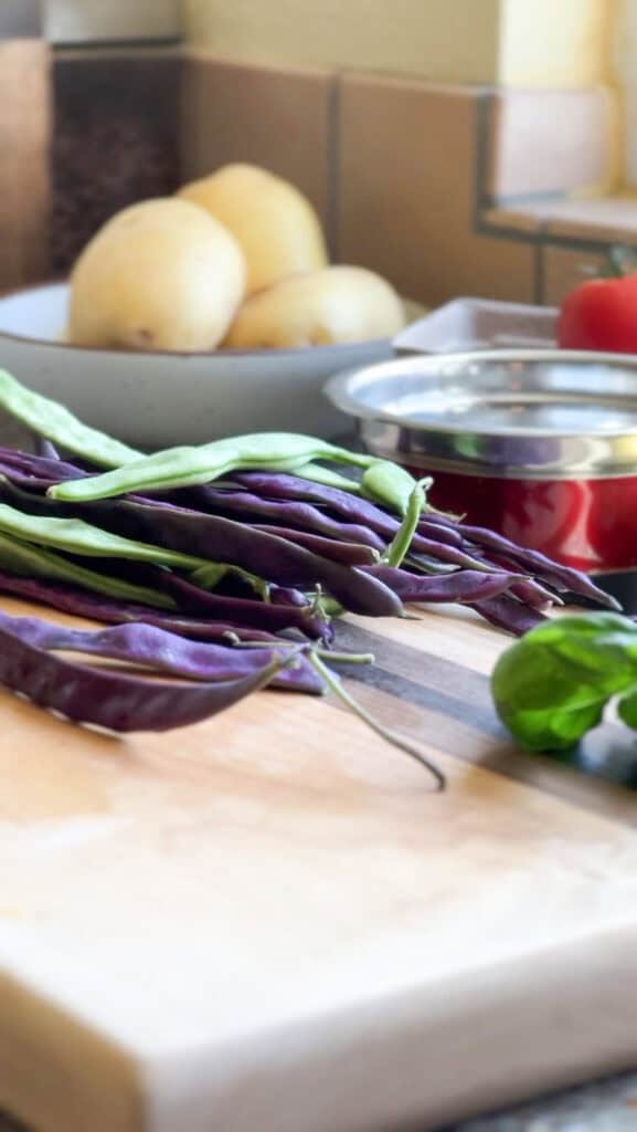 Romano beans being trimmed by a sharp knife.