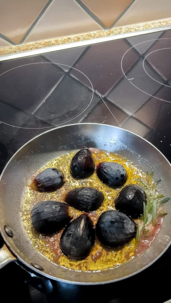 Overhead shot of the halved figs placed cut side down in the skillet to caramelize.